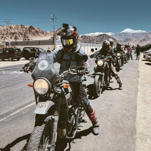 Motorcyclists embarking on a scenic adventure ride in Leh, Ladakh with stunning mountain views.