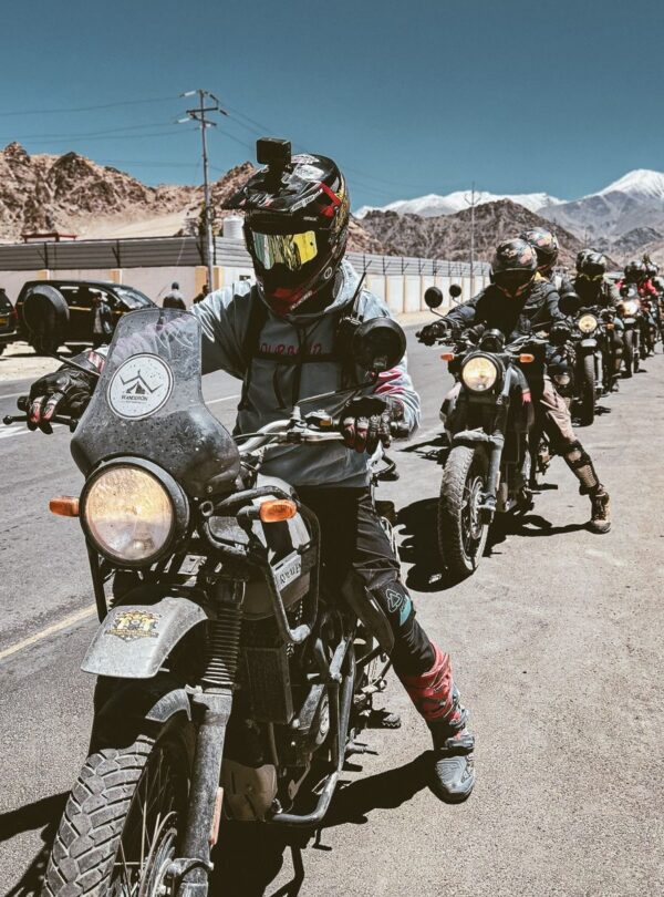 Motorcyclists embarking on a scenic adventure ride in Leh, Ladakh with stunning mountain views.