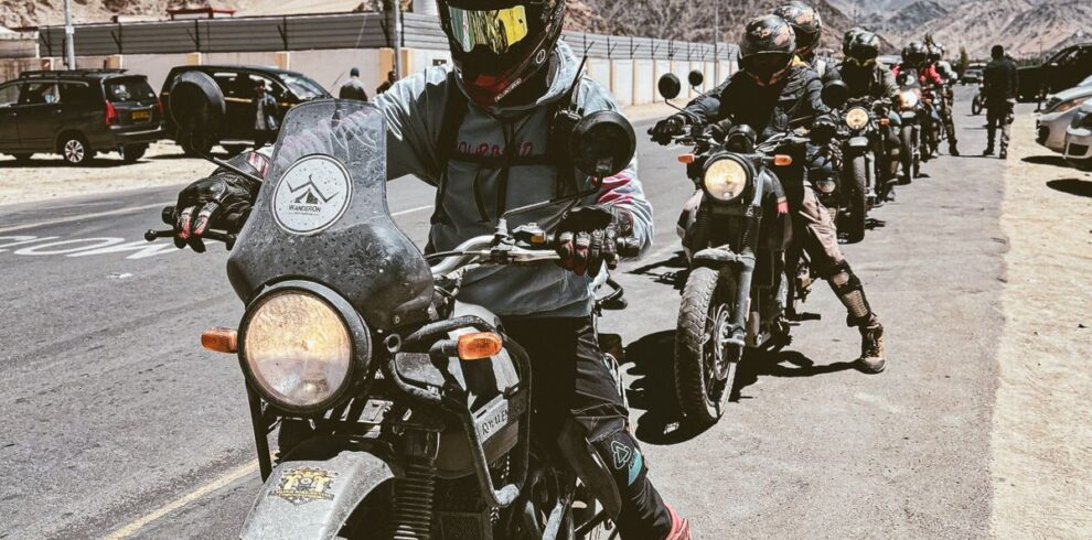 Motorcyclists embarking on a scenic adventure ride in Leh, Ladakh with stunning mountain views.