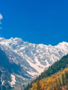 Captivating snow-capped mountains with vibrant autumn foliage in Himachal Pradesh, India.